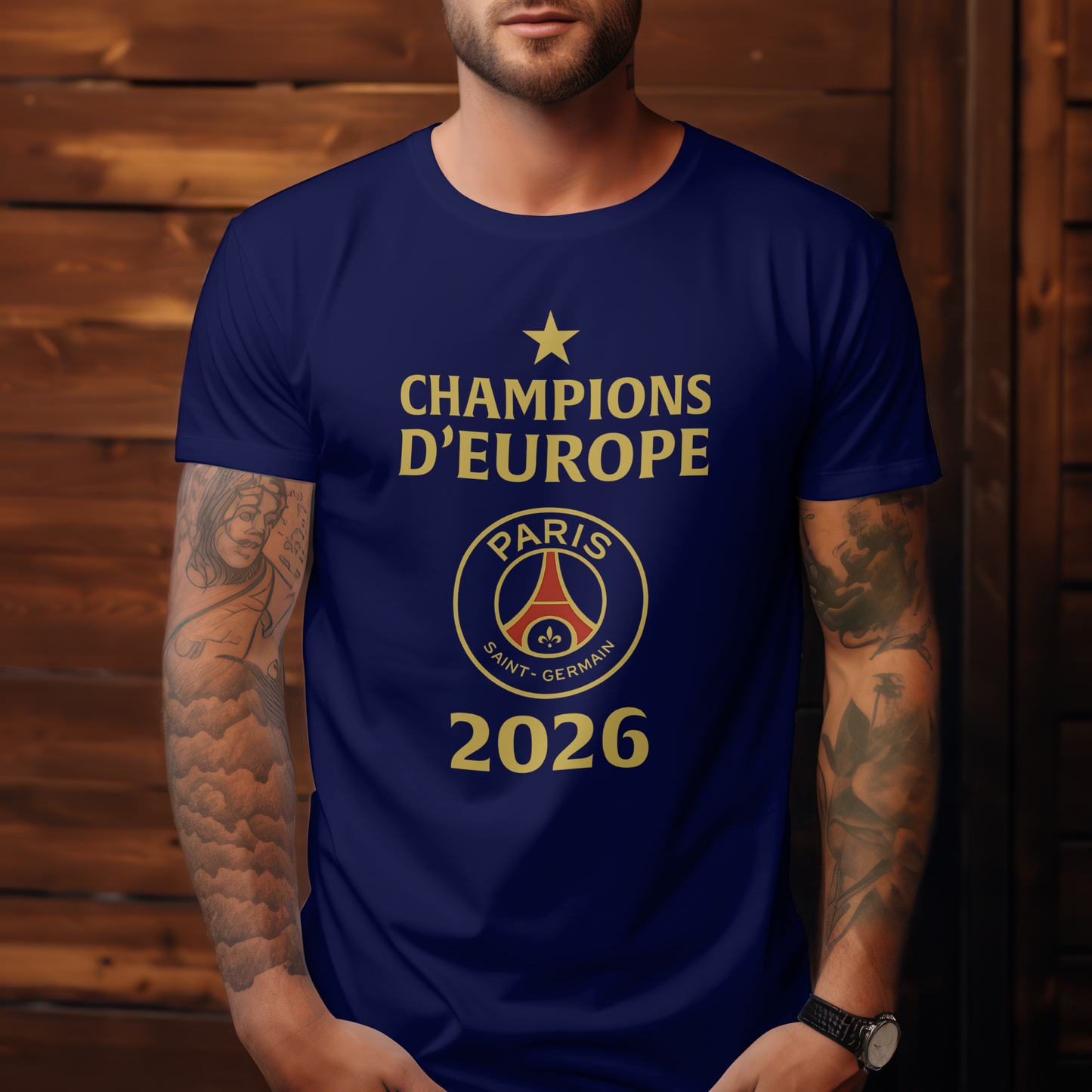 A navy unisex t-shirt featuring the design includes a gold star at the top, the words 'CHAMPIONS D’EUROPE' in gold, the Paris Saint-Germain crest in the center, and the year '2026' in large gold numbers. European Champions League 2026